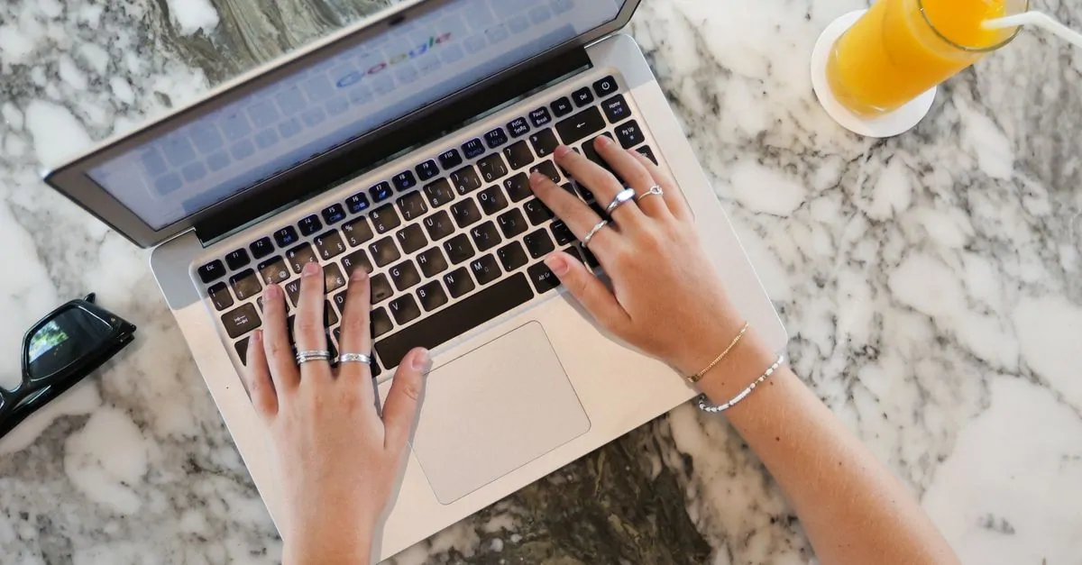 Entrepreneur typing on a laptop to check whether a domain name is still available