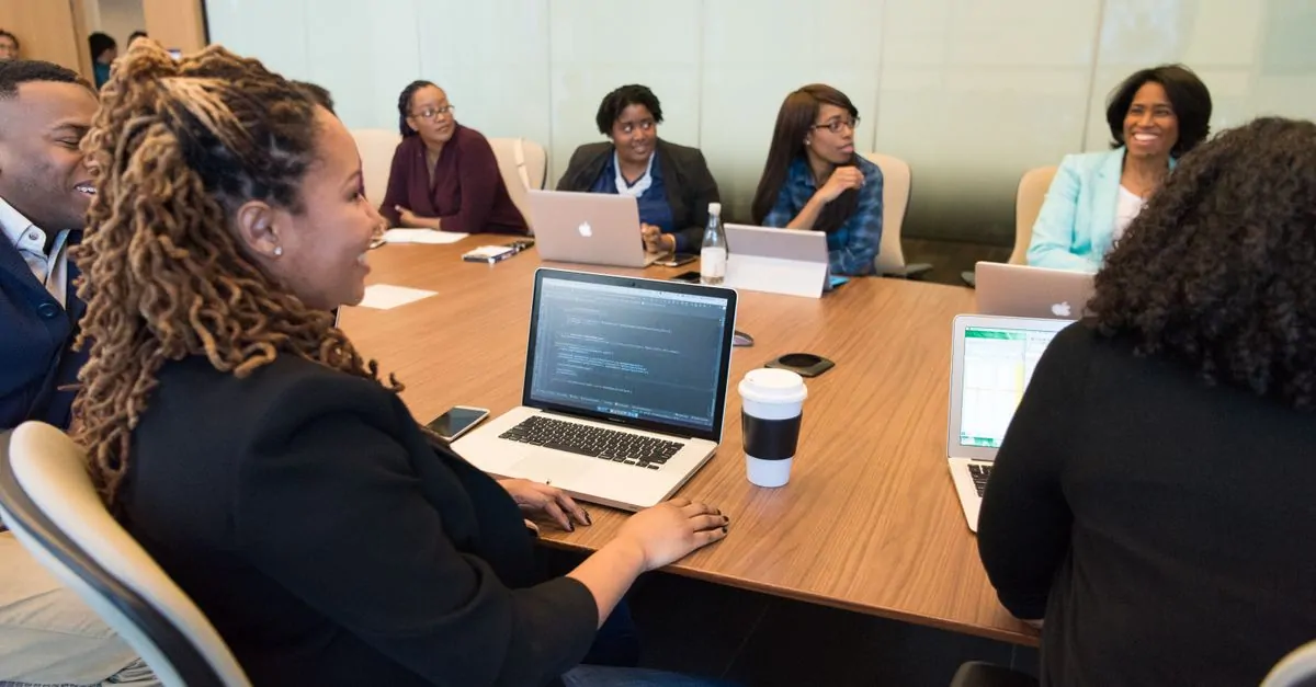 Two colleagues working together on a laptop in an office