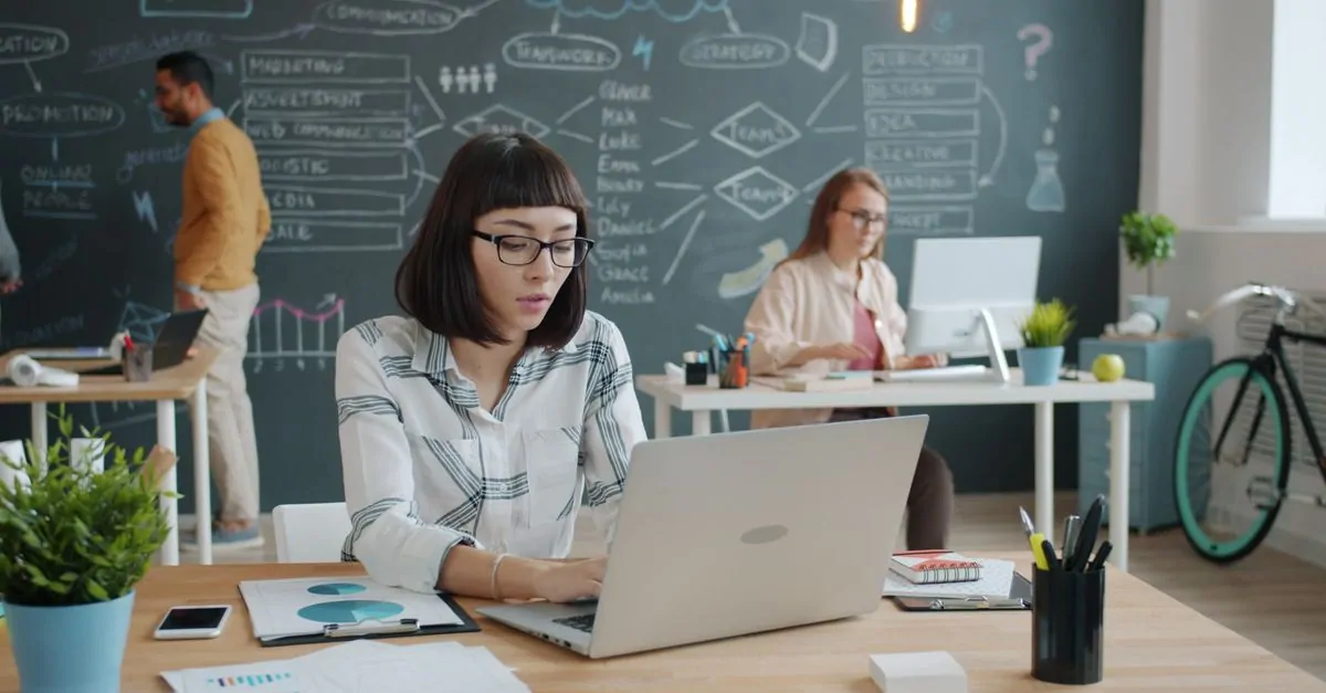 Ondernemer achter een laptop aan een bureau, bezig met het registreren van een domeinnaam
