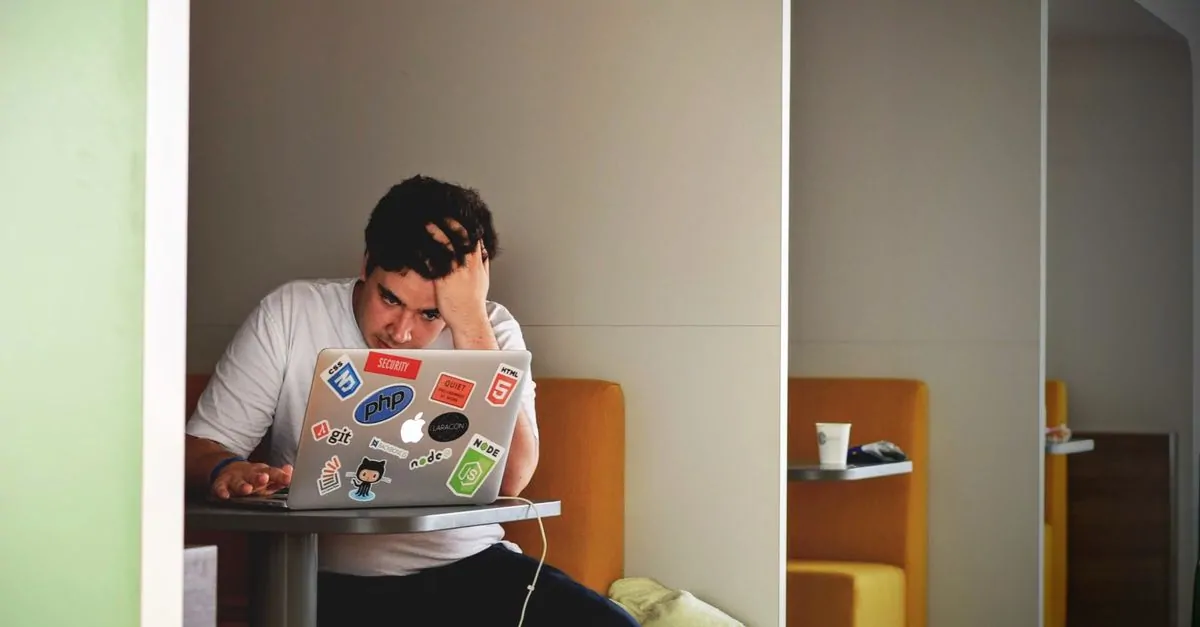 Ondernemer kijkt bezorgd naar een laptop omdat zijn website is gehackt